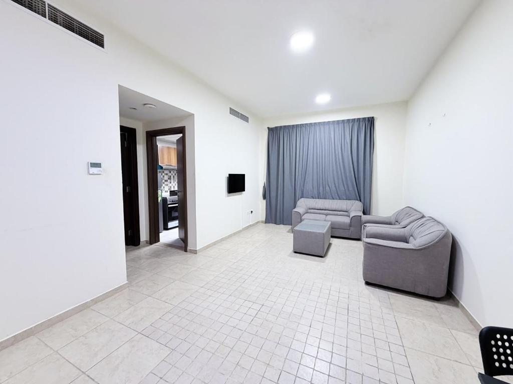 a living room with two couches and a tv at Rose Building in Dubai