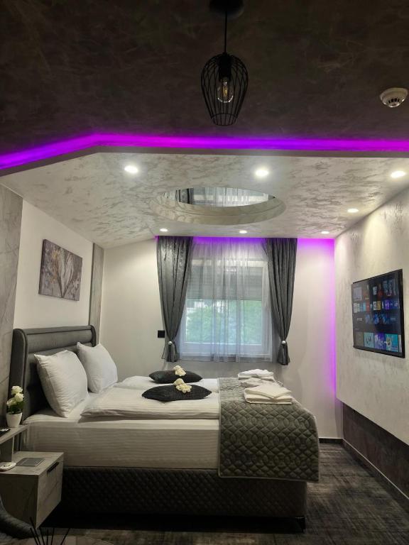 a bedroom with a bed with purple lighting at Ambasada Rooms in Sarajevo