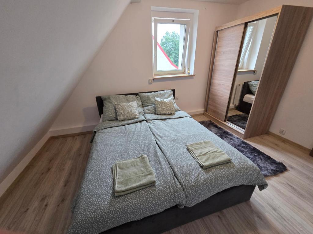 a bedroom with a large bed with two pillows at Cozy Attic Apartment Koszalin in Koszalin