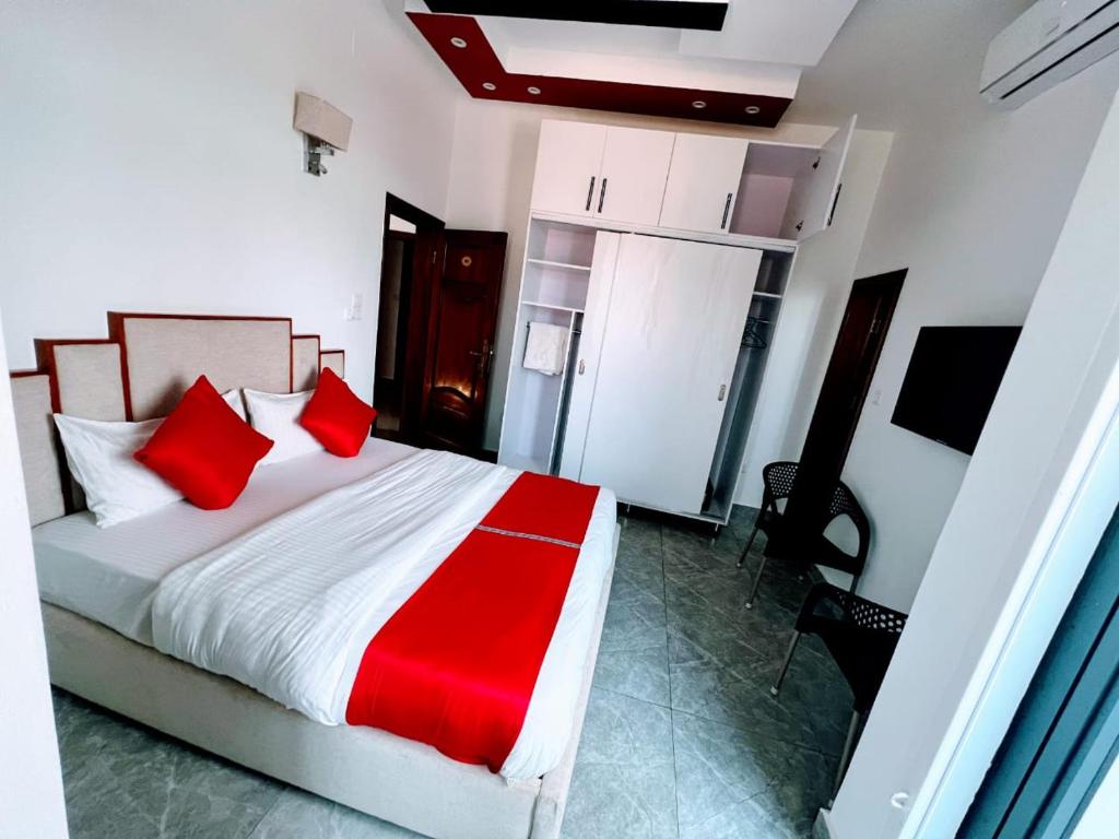 a bedroom with a large bed with red pillows at Comfort Deluxe Apart in Kigali