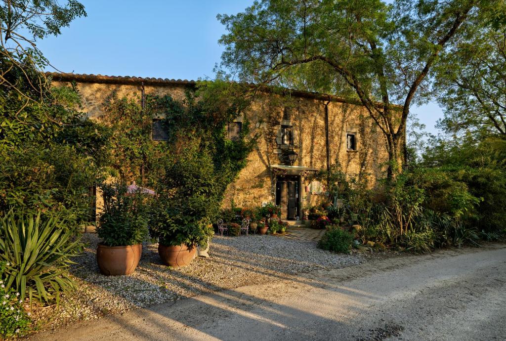 a stone building with potted plants in front of it at Can Portell by 123ole, B&B - Casa Rural in Sant Andreu del Terri