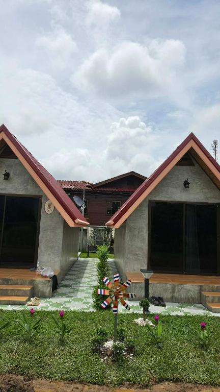 a small house with a porch and a driveway at บ้านสวนแม่จันทร์เพ็ญ in Chiang Dao