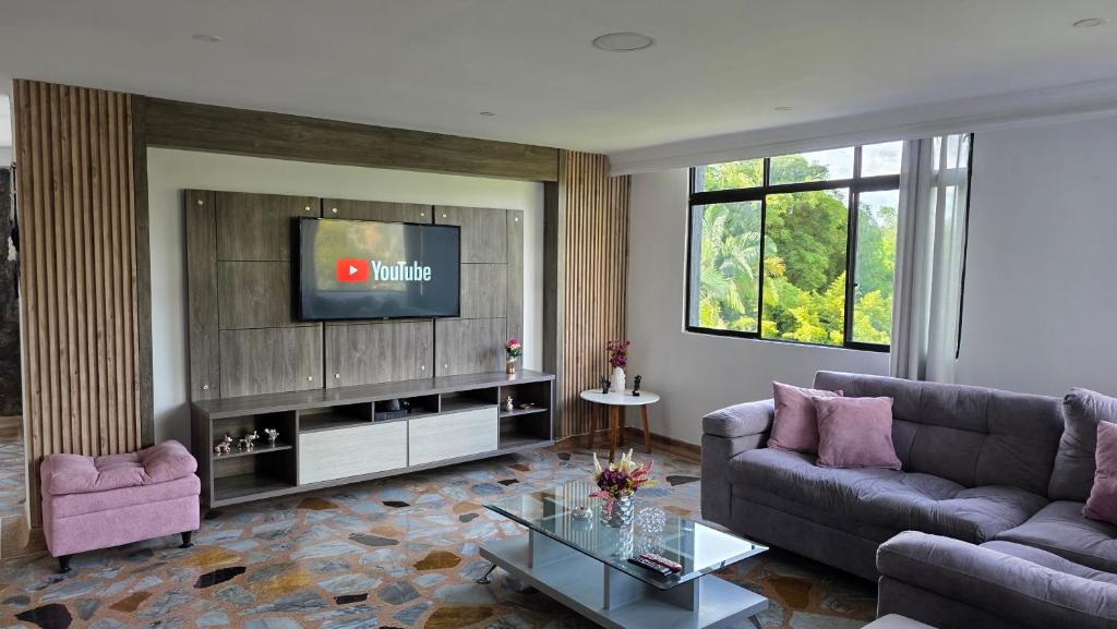 a living room with a couch and a tv at Pent House La Castellana in Armenia