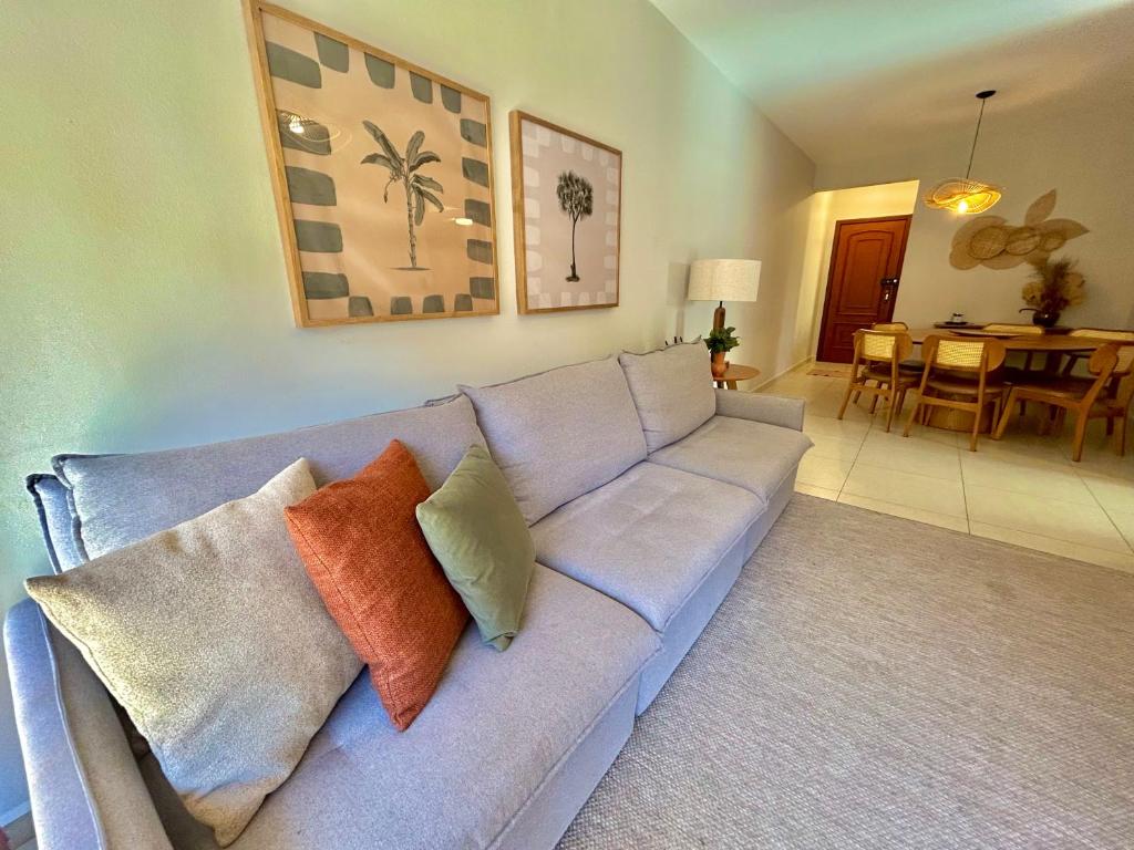 a living room with a blue couch with pillows at Edifício Barão Filippi in Águas de Lindoia