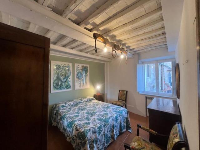 a bedroom with a bed and a desk and a window at La terrazza del Conte in Siena