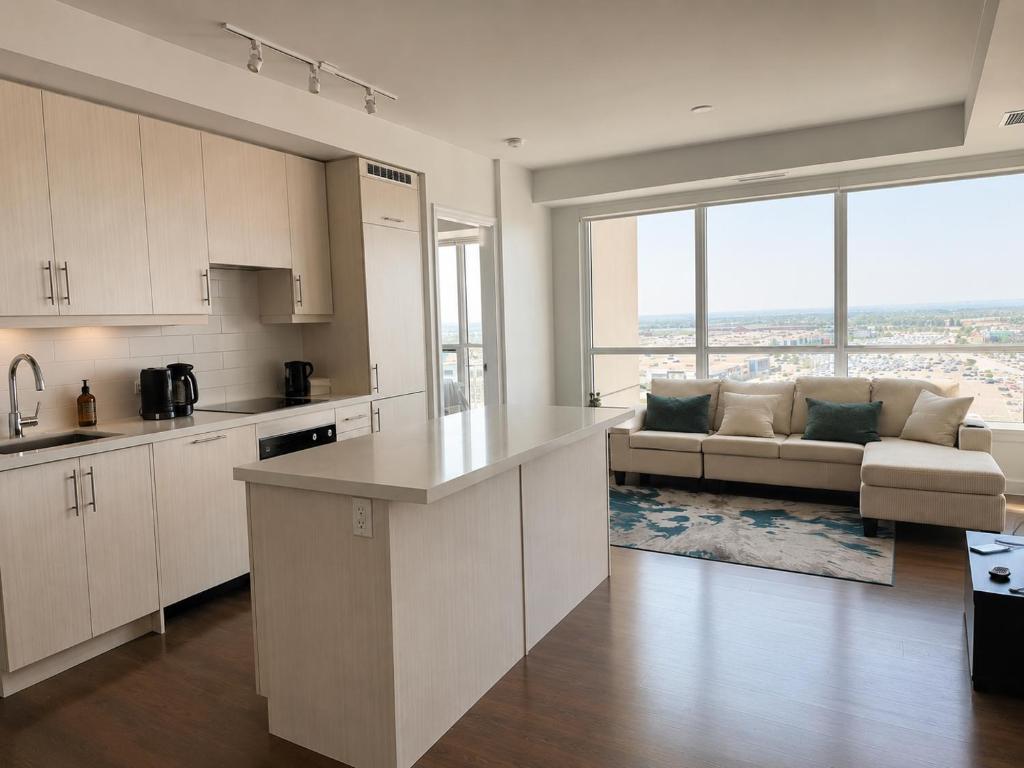 a kitchen with white cabinets and a couch in a living room at SimplyBnB in Vaughan