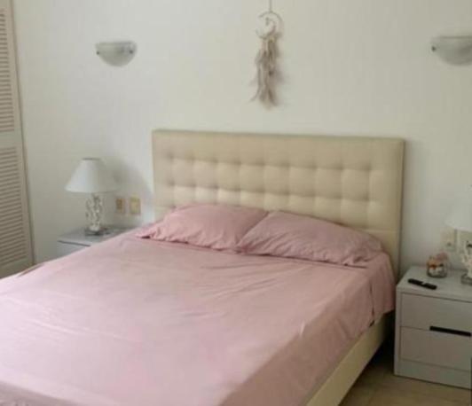 ein Schlafzimmer mit einem großen Bett und einer rosa Decke in der Unterkunft Torres del mar in Same