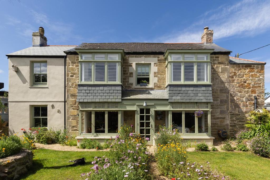 a stone house with a garden in front of it at Penwyth House in Newquay