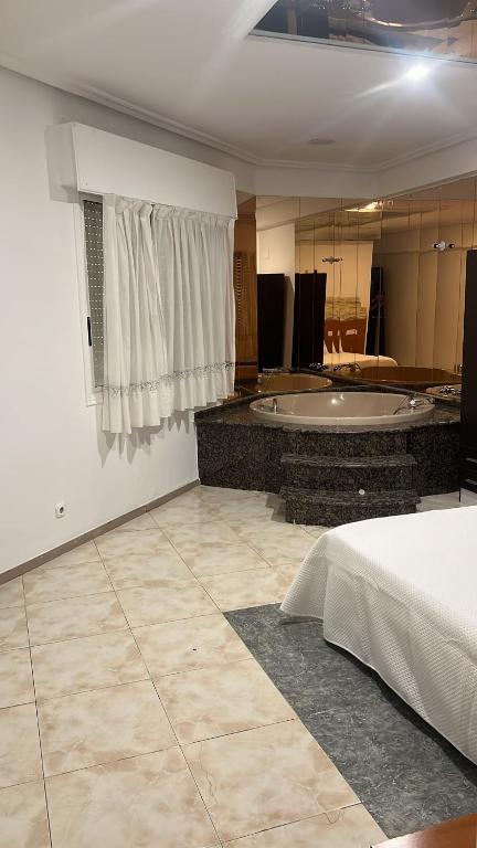 a large room with a bath tub and a bed at Hotel Termas Camino Real in Ourense