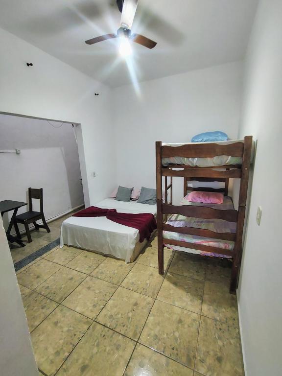 a bedroom with a bed and a ceiling fan at Kitnet Centro in Capitólio