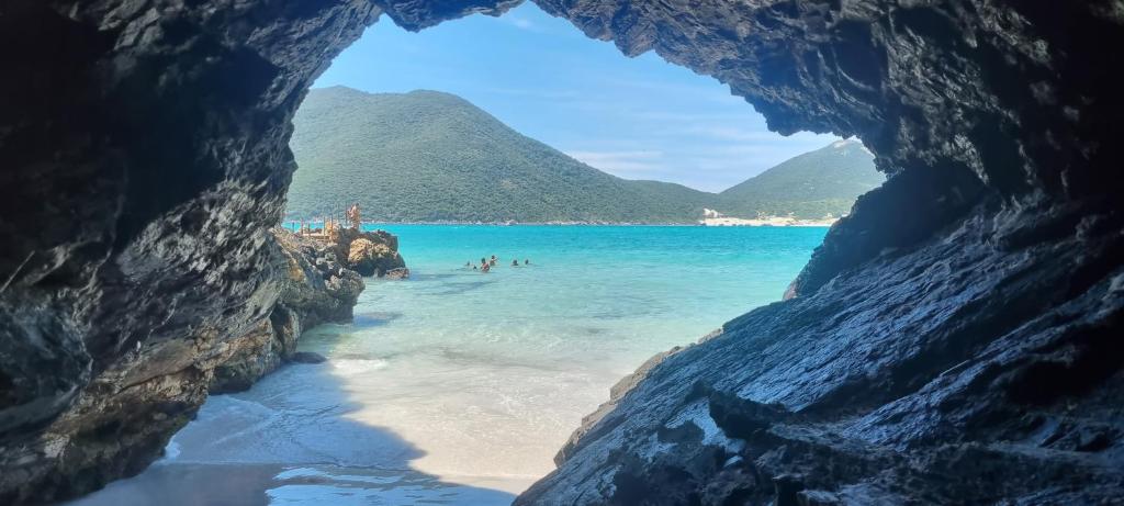 a view of a beach through a cave at Apart-Hotel Golden Lake 2 in Arraial do Cabo