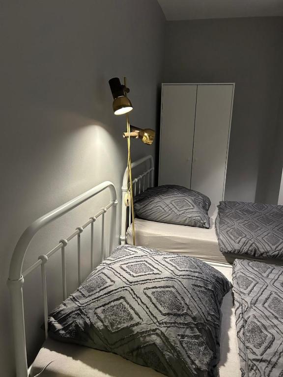 a bedroom with two twin beds and a lamp at Freedom Studio Apartment in Berlin