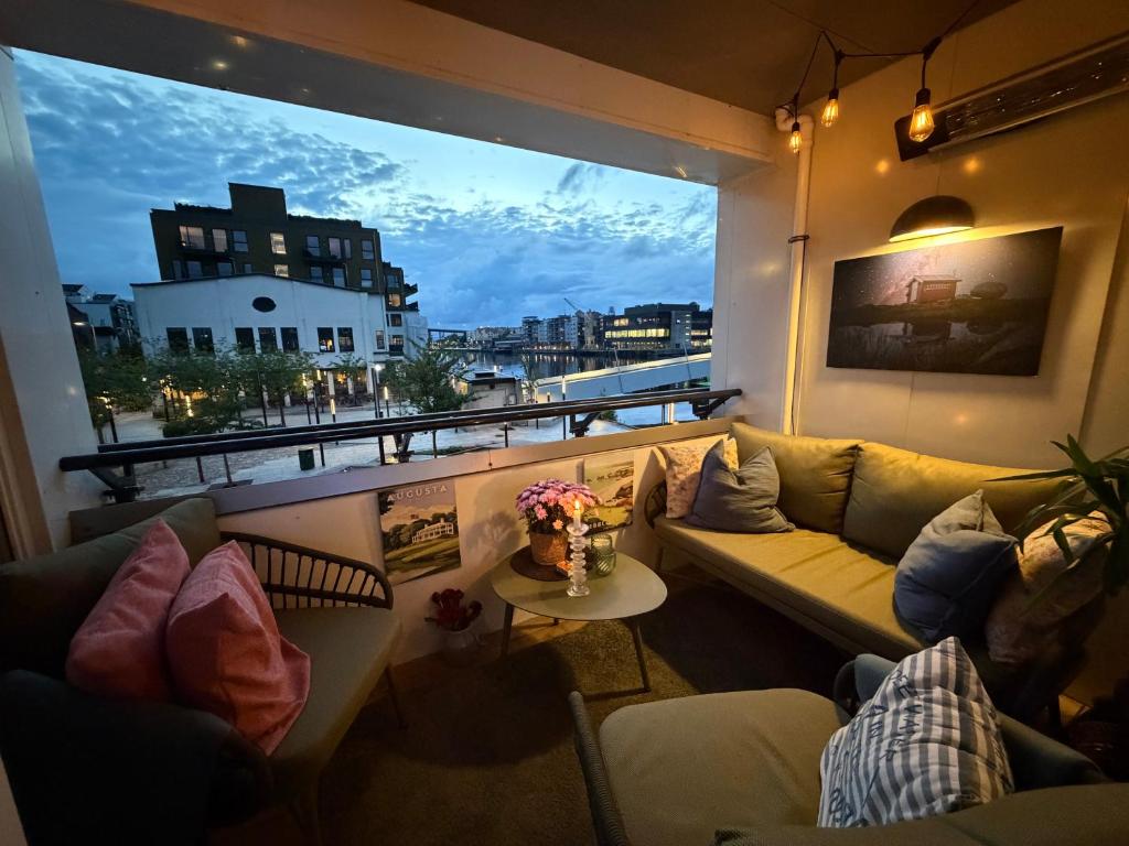 a living room with a couch and a large window at Sentrumsnær leilighet Bergen in Bergen