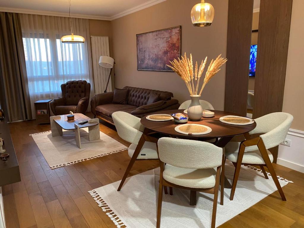 a living room with a table and chairs and a couch at Velvet Point apartmant in Kragujevac