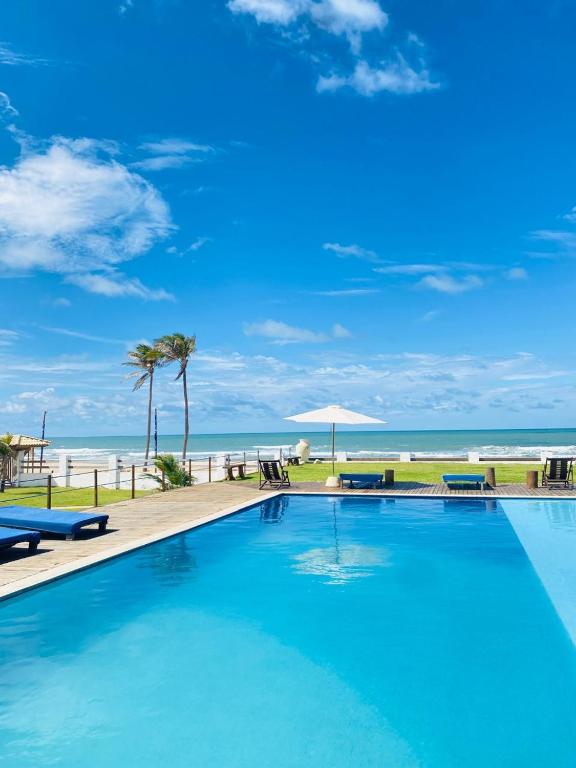 a swimming pool with the beach in the background at Villa Ava Kite - Guajiru in Trairi