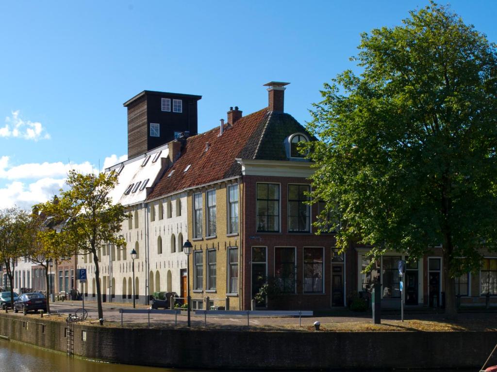 a building on the side of a river at Het Dakhuis in Harlingen