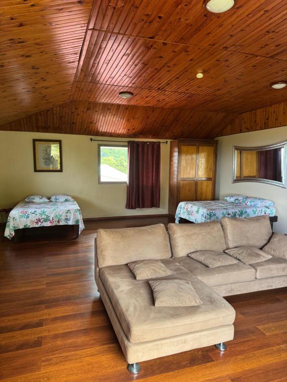 a living room with a couch and two beds at Studio indépendant in Otutara