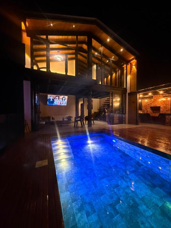 a swimming pool in front of a building at night at Kilamo sky glamping macas in Macas