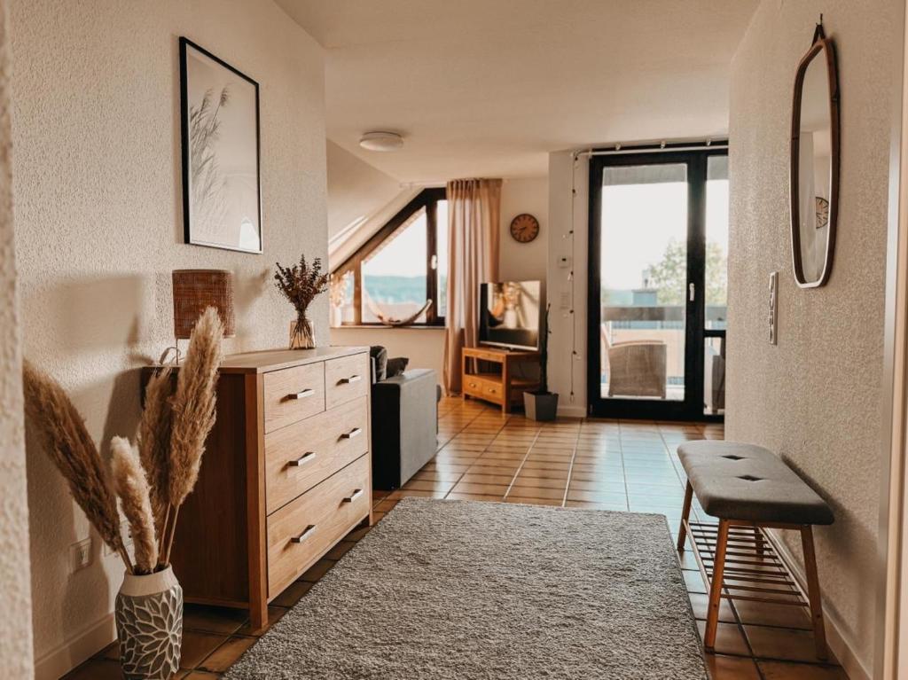 a living room with a dresser and a large window at Ferienwohnung Südblick in Barntrup
