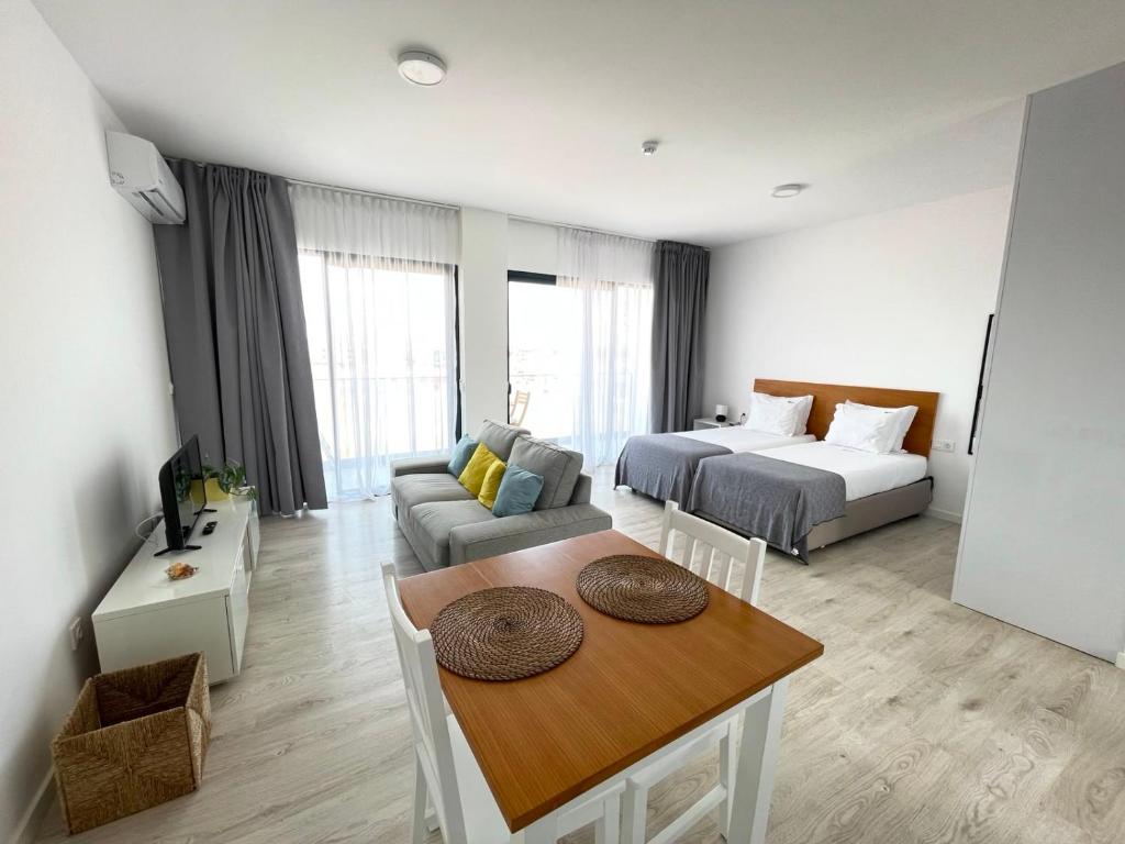 a living room with a couch and a bed and a table at Apartamento T0 - MedSal Residence in Prainha