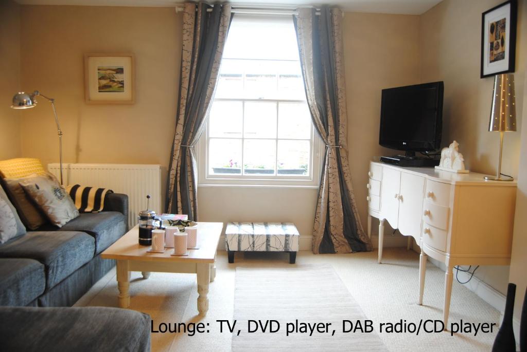 a living room with a couch and a tv at High Street Apartment in Uppingham
