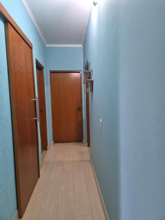 a hallway with a wooden door and a hallwayngth at Refúgio triplo por pessoa in Paulínia