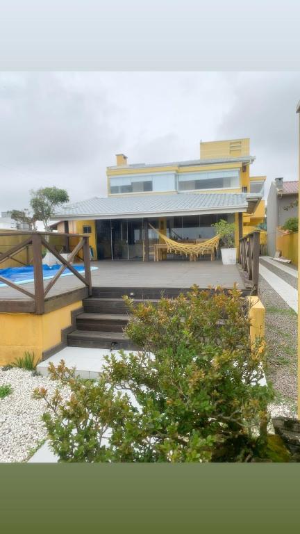 a house with a staircase in front of it at Casa amarela in Navegantes
