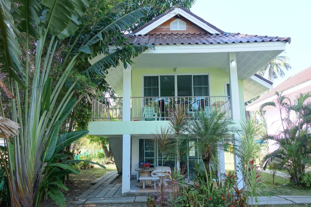 a white house with a balcony and plants at Mook Ing Lay in Ko Mook