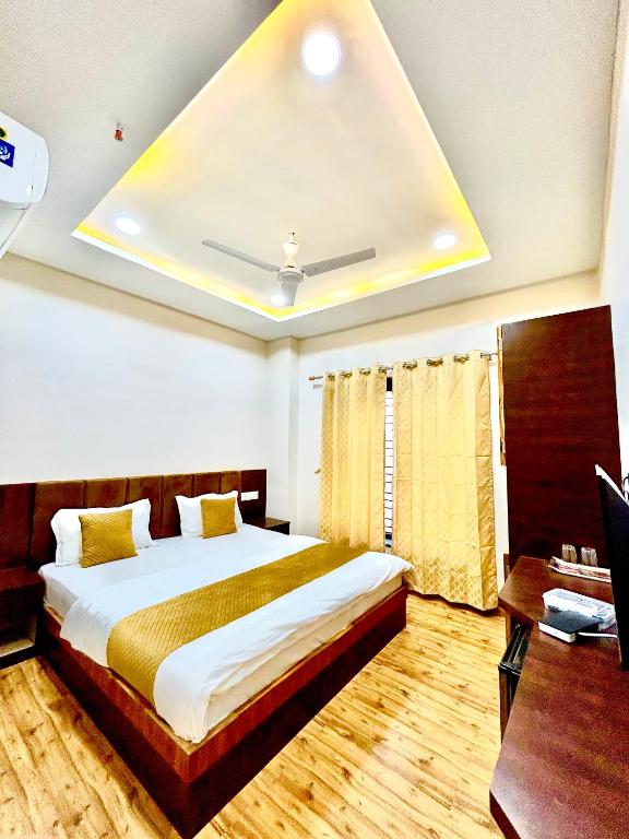 a bedroom with a large bed with a ceiling at Shree Gurukripa Inn in Maheshwar
