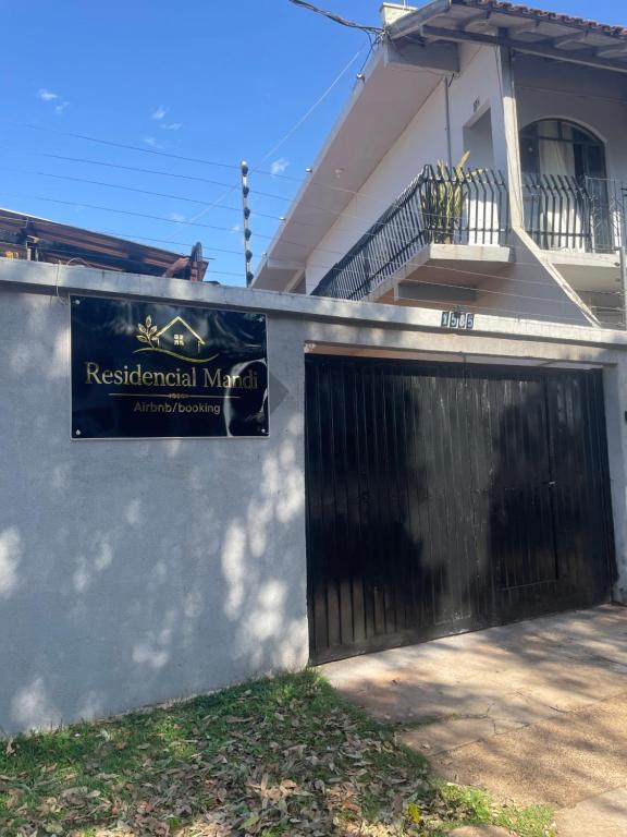 a sign on the side of a house with a gate at Residencial Mandi in Guaíra