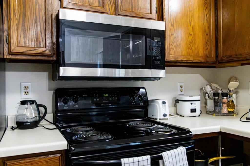 a kitchen with a black stove with a microwave at Cozy house in Moorhead