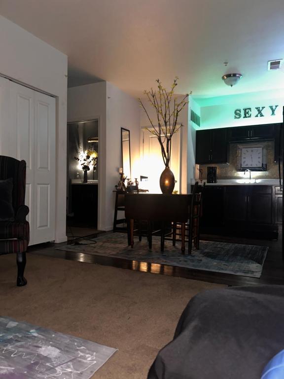 a living room with a table and a kitchen at Union at the loop in Lawrence