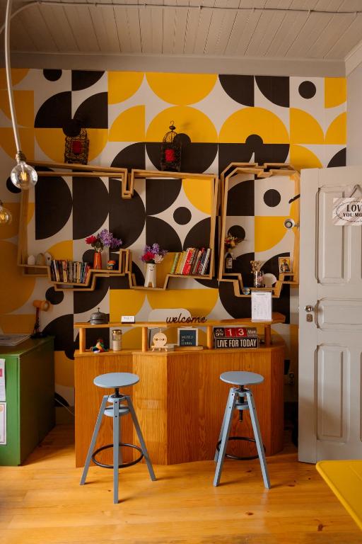 a room with two stools and a cow patterned wall at Most Art Boutique Hostel in Leiria