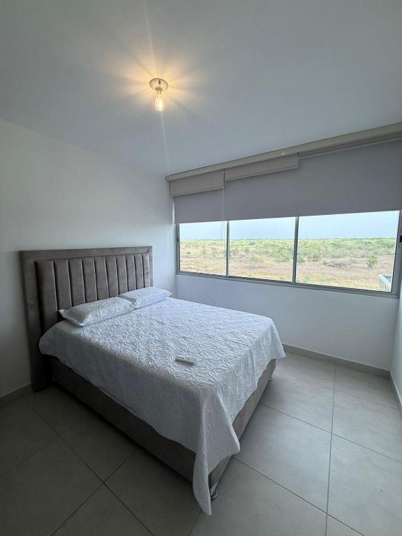 a bedroom with a bed and a large window at Sensacional Apartamento Serena del Mar in Serena del Mar