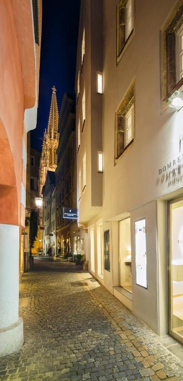 a cobblestone street in a city at night at Domresidenz Regensburg in Regensburg