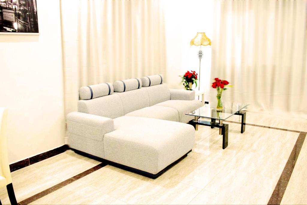 a living room with a white couch and a table at Leader Hotels Salmiya in Kuwait