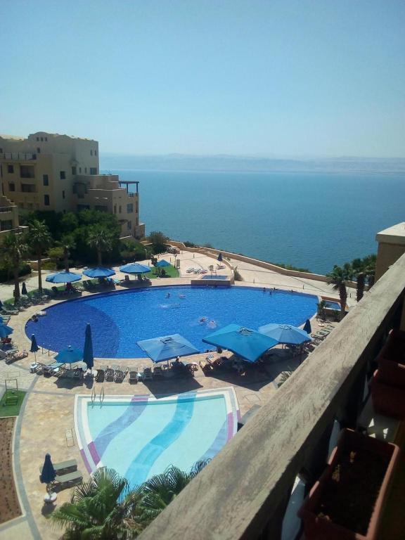 a view of a swimming pool with umbrellas and the ocean at SAMARAH RESORT - D35 apartment in Sowayma