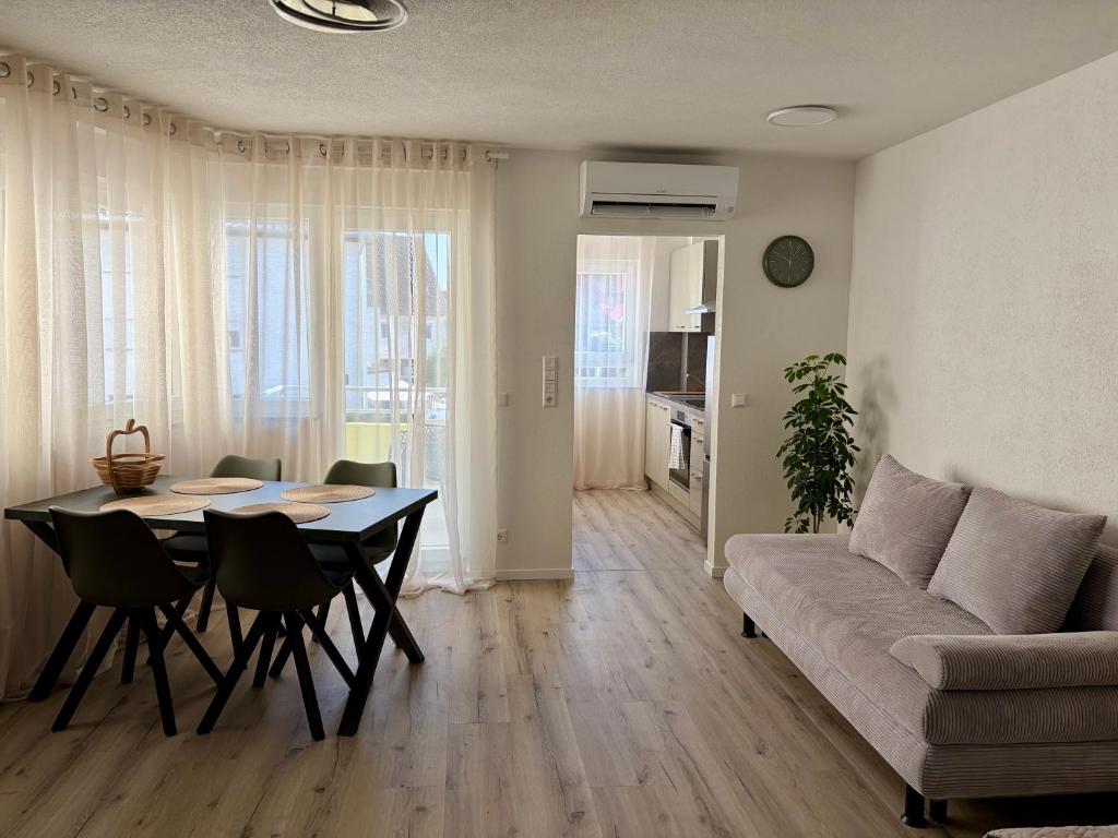 a living room with a table and a couch at Darius Apartment Kehl in Kehl am Rhein