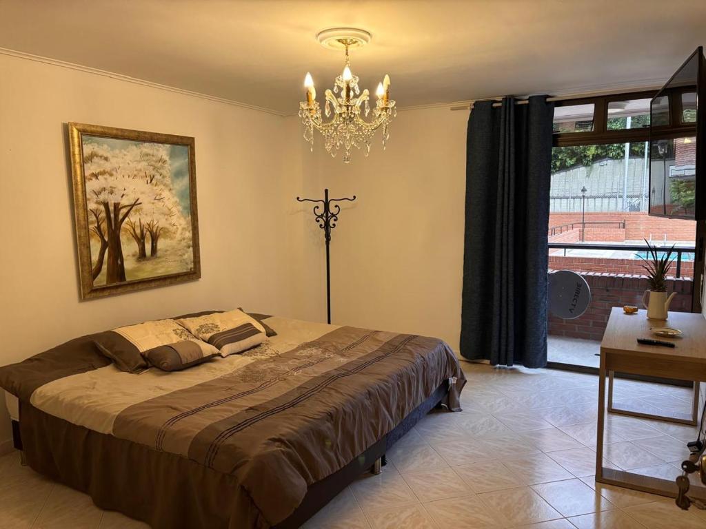 a bedroom with a large bed and a chandelier at Villa del Tesoro in El Poblado