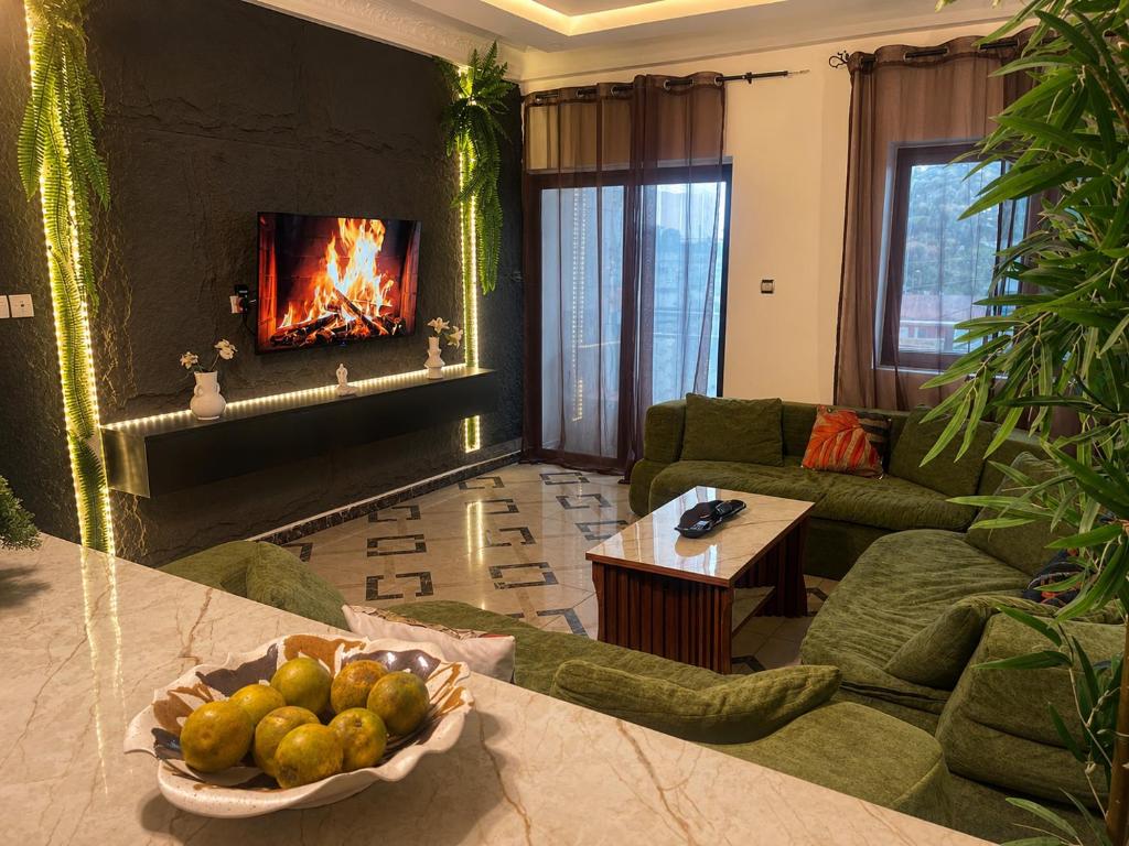 a living room with a fireplace and a bowl of fruit at Kaz An Nou in Cotonou