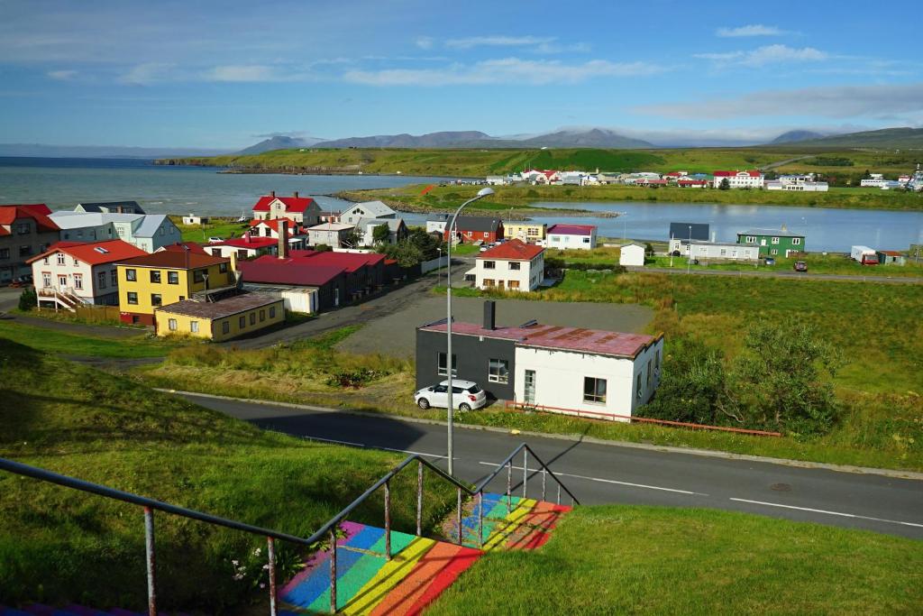 a small town with a body of water and a street at Sólheimar in Blönduós