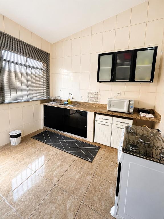 a kitchen with a sink and a stove in it at Casa Spring in Alfenas