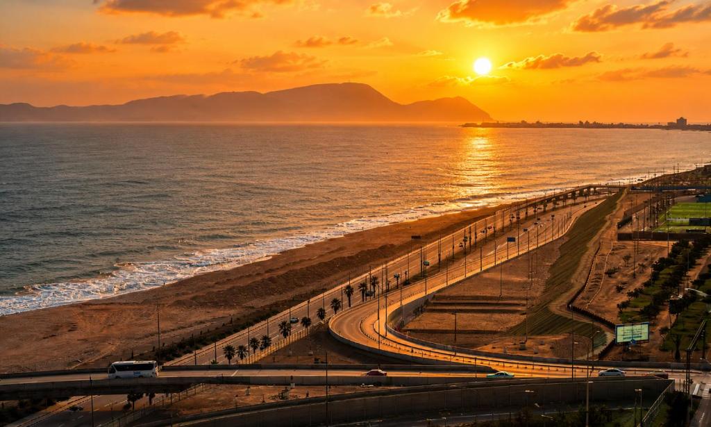 a beach at sunset with the sun setting over the ocean at Perfect Balance Rest and Work Study Oceanfront in San Antonio
