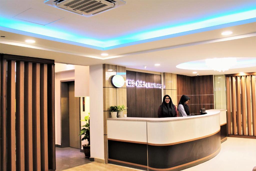 two women standing at a reception desk in a lobby at ECO Hotel at Bukit Bintang in Kuala Lumpur