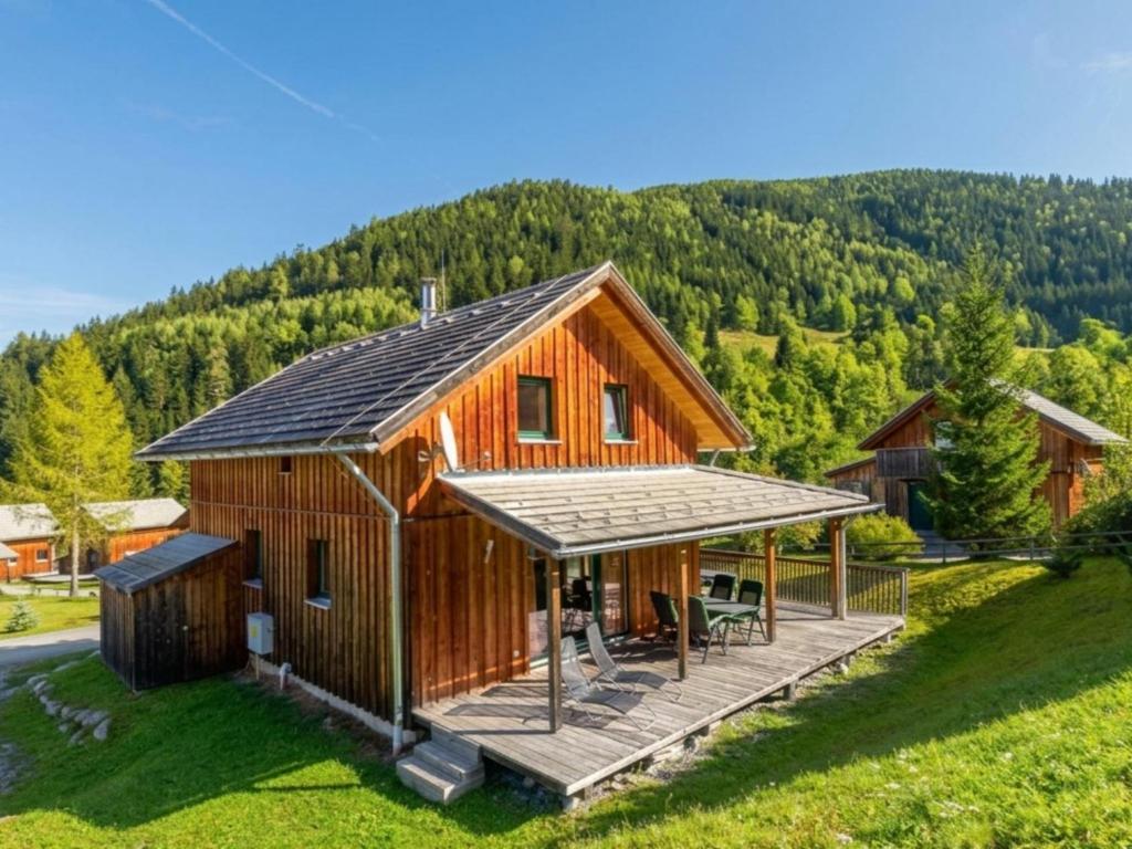 a large wooden cabin with a deck and a mountain at Baier in Stadl an der Mur