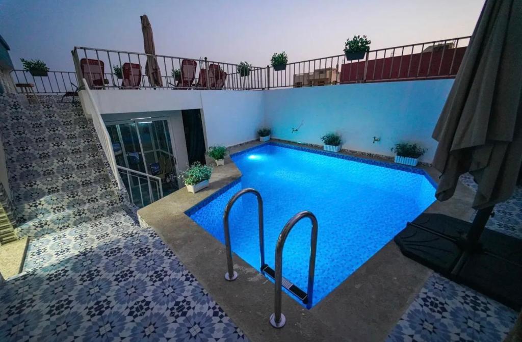 a swimming pool with blue water in a building at Bella Vista Surf Camp in Tamraght Ou Fella