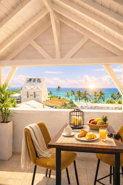 a dining room with a table with a view of the ocean at Ocean Eleven Boutique Stay - Sea View Sunset Terrace in Sainte-Anne