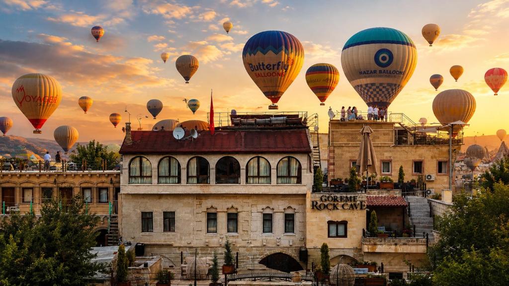 a group of hot air balloons flying over a building at Göreme Rock Cave in Göreme