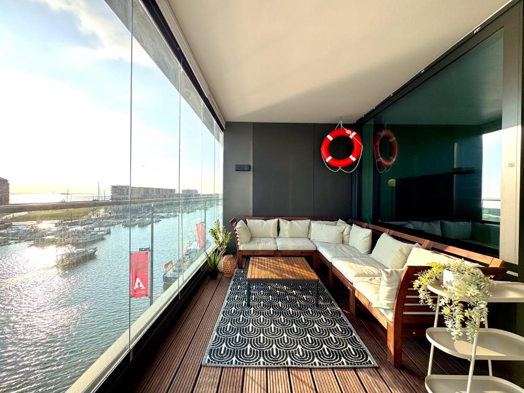 a living room with a couch and a view of the water at Bheaven I Captains Apartment in Bremerhaven