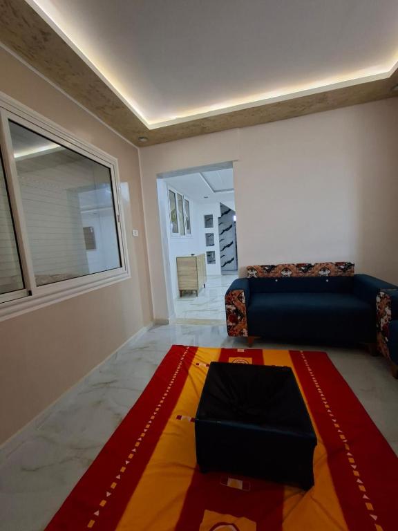 a living room with a couch and a rug on the floor at Omaima villa in Taguermess